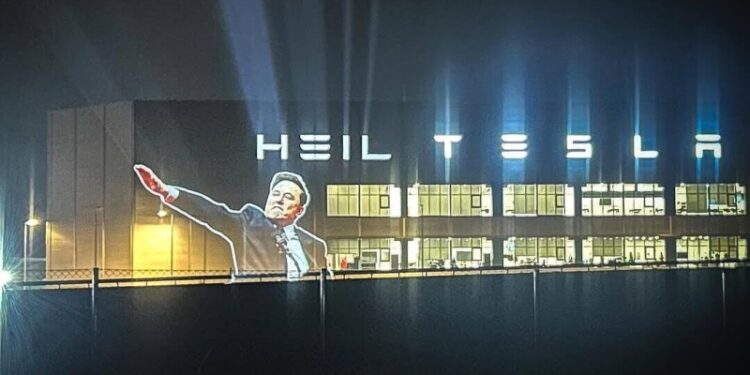 На фасад завода Tesla в Берлине вывели проекцию с жестом Маска
